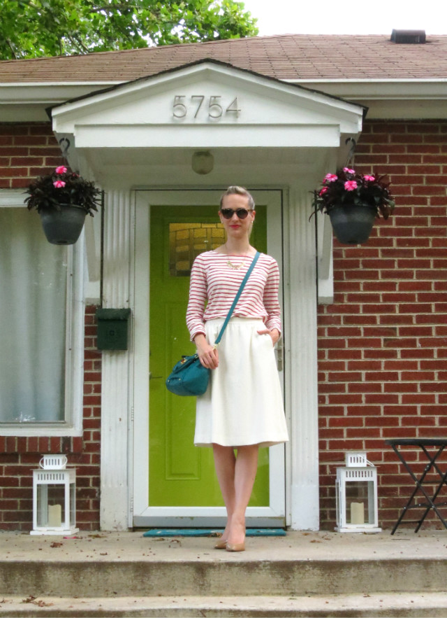 brick house with bright green door, white midi skirt, pink nautical stripe tee, teal Target bag, patent nude pumps