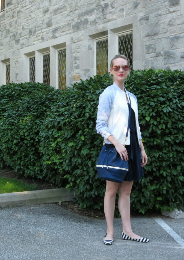 navy fit and flare dress, varsity jacket, bucket bag, striped flats outfit