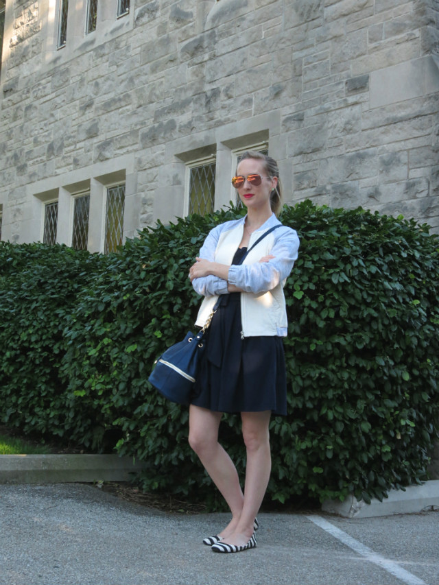 navy fit and flare dress, varsity jacket, bucket bag, striped flats outfit