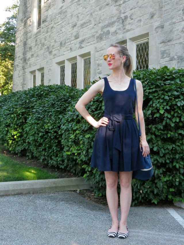 navy fit and flare dress, varsity jacket, bucket bag, striped flats outfit