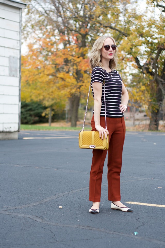 rust colored ankle pants, black and white stripe tee, yellow Rebecca Minkoff bag, Skagen watch, cap toe flats