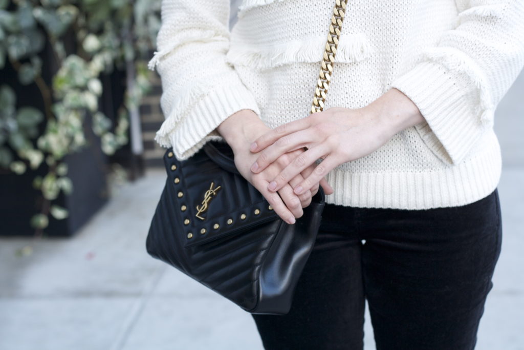 cream fringe sweater, velvet skinny jeans, YSL college bag, metallic loafers