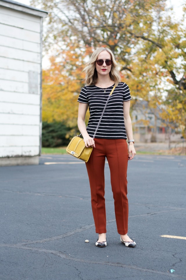 rust colored ankle pants, black and white stripe tee, yellow Rebecca Minkoff bag, Skagen watch, cap toe flats