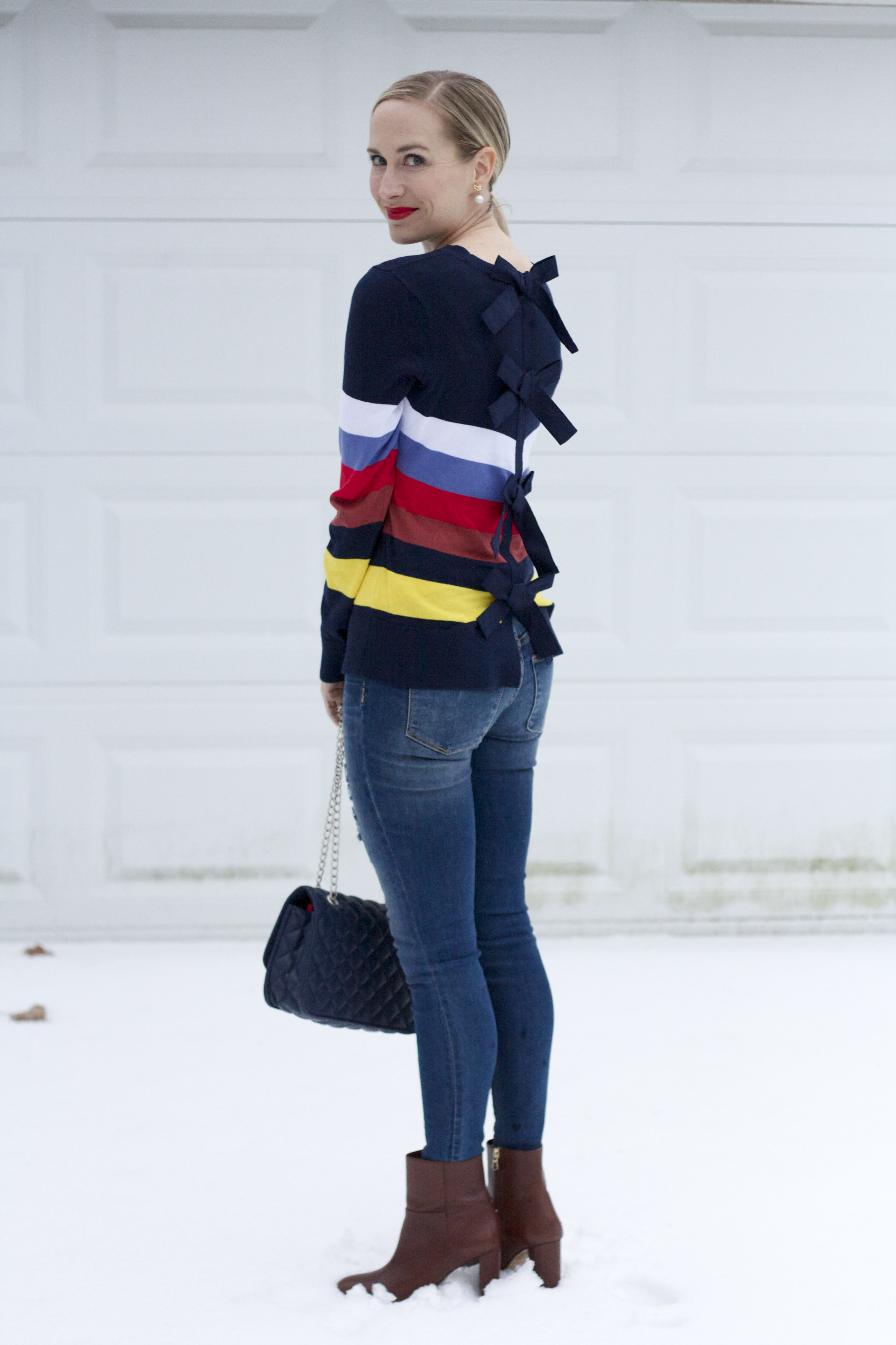 bow back sweater, jeans and ankle boots, quilted bag